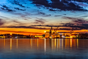 Fototapeta na wymiar Sunset over an industry harbor with cranes in Stavanger, Norway.