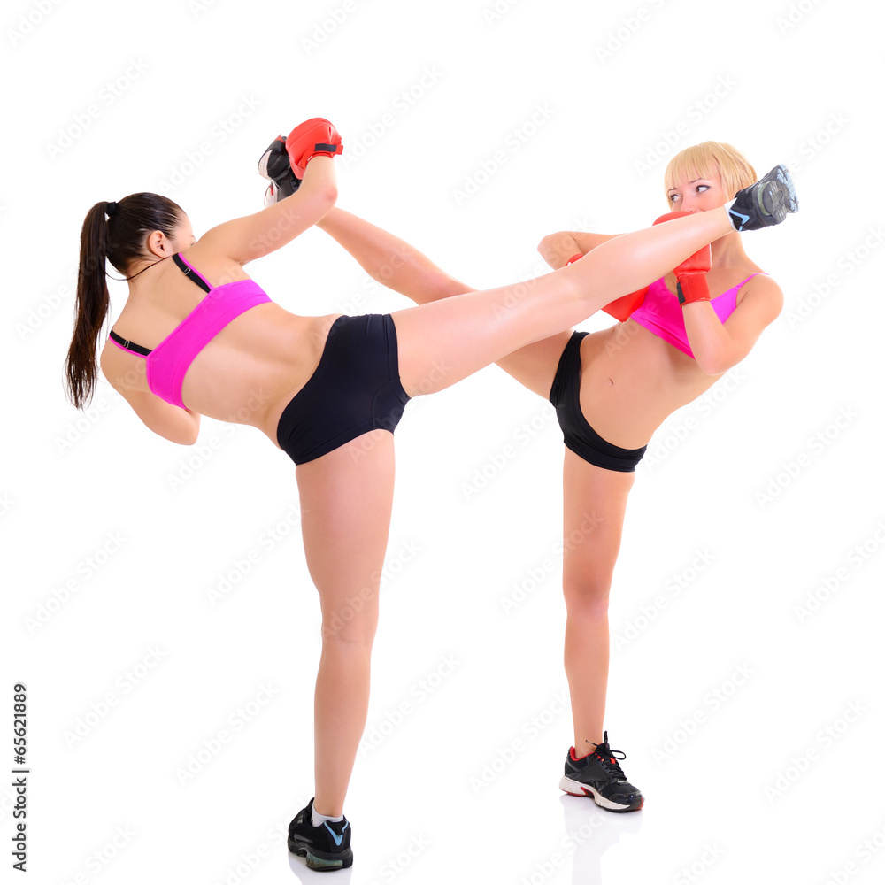 Wall mural sport training of two boxing young woman, studio over white