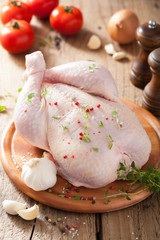 whole raw chicken with rose pepper and thyme © Olga Miltsova