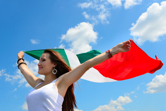 young beautiful cheerful woman holding italian flag against summ