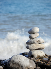 Close-up of white pebbles stack over blue sea.