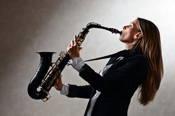 Obraz na płótnie Canvas young beautiful woman with saxophone
