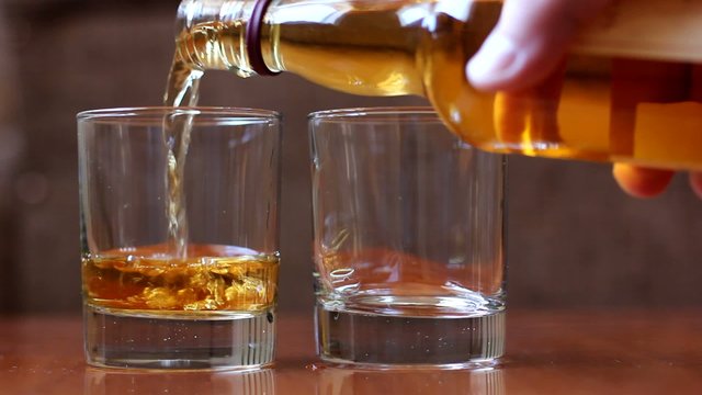 Pouring scotch whiskey in glass