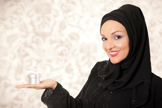 Model dressed in traditional Arabic style, holding present box