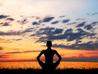 Sunset meditation. Silhouette of a woman doing yoga.