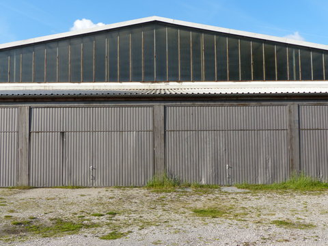 Flugzeughangar mit Toren aus Wellblech im Sommer bei Sonnenschein am Segelflugplatz in Oerlinghausen bei Bielefeld am Hermannsweg im Teutoburger Wald in Ostwestfalen-Lippe
