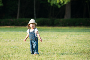 Little girl walking in the green grass
