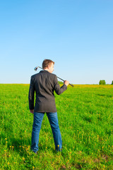 businessman with a golf club on the field