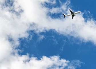 Fototapeta na wymiar Airplane over cloudy sky background