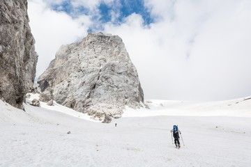 Fototapeta na wymiar Skiiers ascending mountain slope
