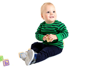 Cute young toddler boy holding a toy alphabet block