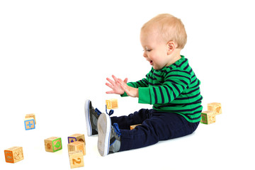 Adorable young toddler boy playing with toy blocks