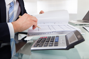 Businessman Holding Calculating Expense In Office