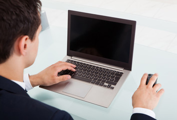 Young Businessman Using Laptop In Office
