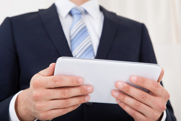 Businessman Holding Digital Tablet In Office