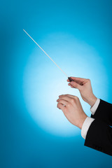 Musician Holding Baton Against Blue Background