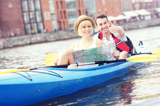 Happy tourists with a map in a canoe