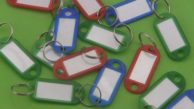Coloured  key tags rotating on a green background.
