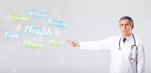 Clinical doctor pointing to health and fitness collection of wor