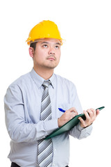 Engineer writing somthing on clipboard and looking up