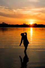 carefree woman dancing in the sunset