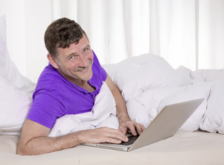 man in bed with laptop