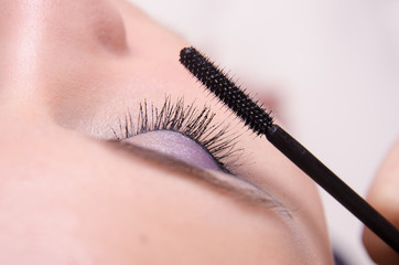 Close-up applying mascara on eyelashes