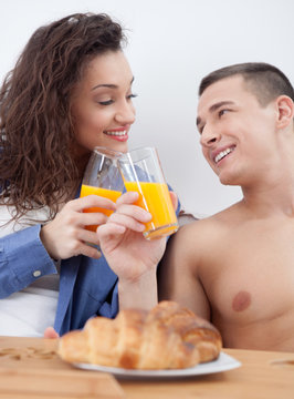  young couple having breakfast in bed toast with orange juice