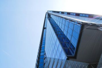Looking up at the glassy Shard, London, against blue sky