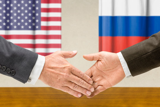 Vertreter der USA und Russlands reichen sich die Hand