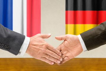 Vertreter Frankreichs und Deutschlands reichen sich die Hand