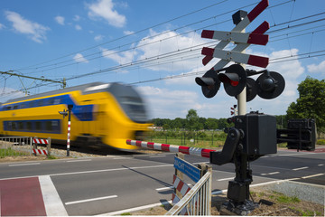 Train riding over a rail crossing in spring