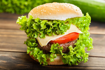 Cheeseburger with lettuce, onions and tomato in a sesame bun