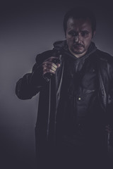 retro portrait of stylish man with long leather jacket, gun arme