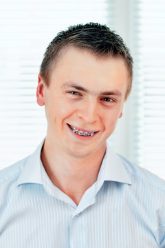 Smiling young man with orthodontic braces.