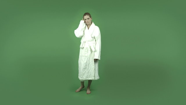 attractive caucasian girl in bathrobe isolated on green thinking