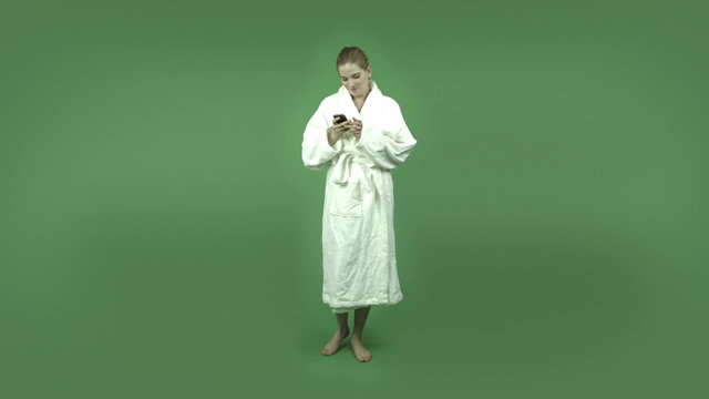 attractive caucasian girl in bathrobe isolated on green taking a
