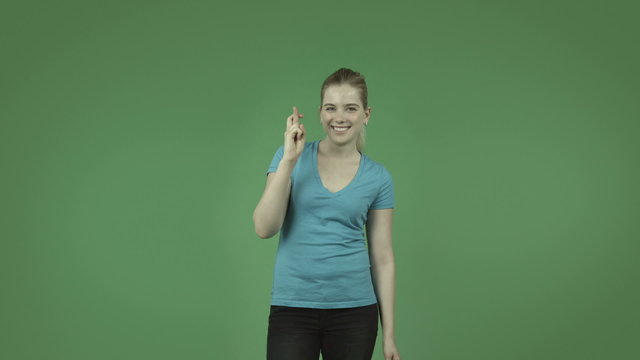 attractive caucasian casual girl isolated on green with fingers