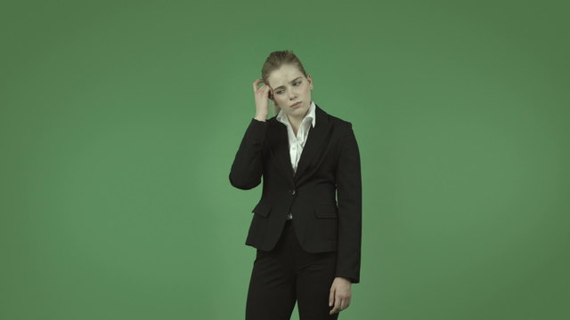 attractive caucasian business girl isolated on green thinking