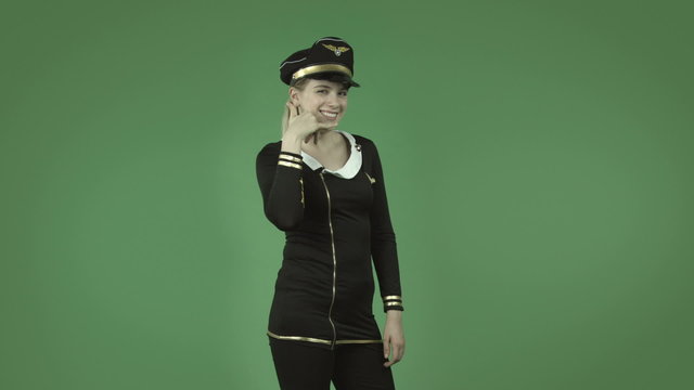 attractive caucasian air hostess isolated on green with call me