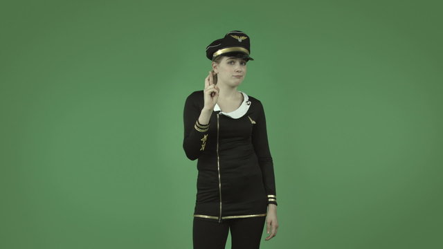 attractive caucasian air hostess isolated on green with fingers