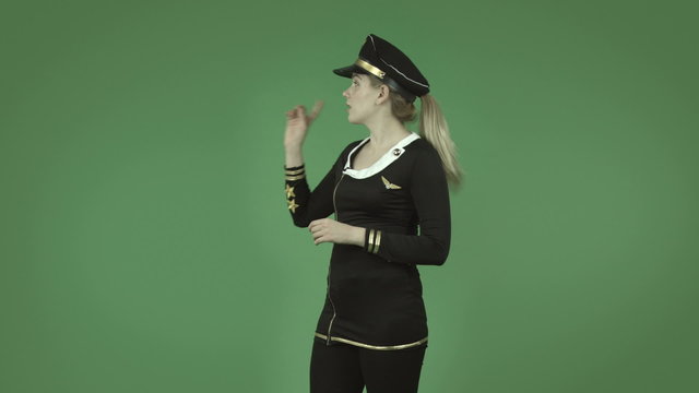 attractive caucasian air hostess isolated on green talking and