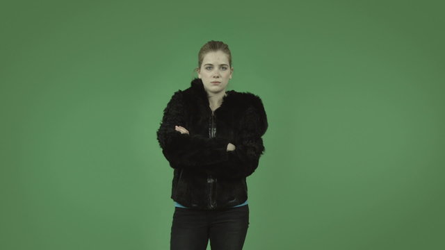 attractive caucasian girl with coat isolated on green upset