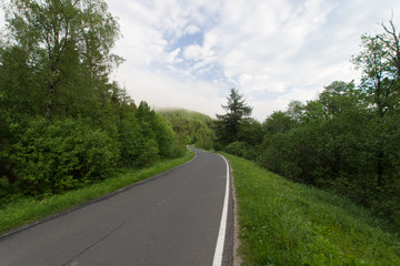 Droga asfaltowa w górach, mglisty poranek, Bieszczady