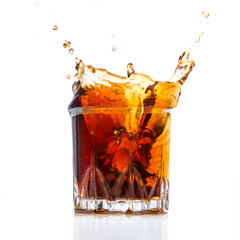 Glass with whiskey splash on white background
