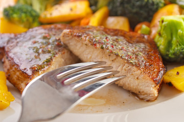 Eating pork fillet steak with roasted vegetables