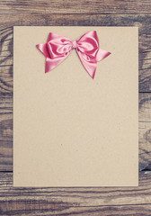 vintage background with wood, old paper and pink bow