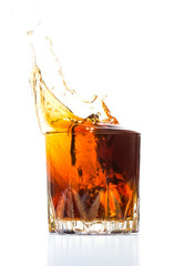 Glass with whiskey splash on white background