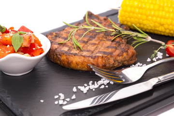 Grilled steak with sauce and greens