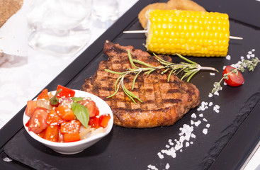 Grilled steak with sauce and greens